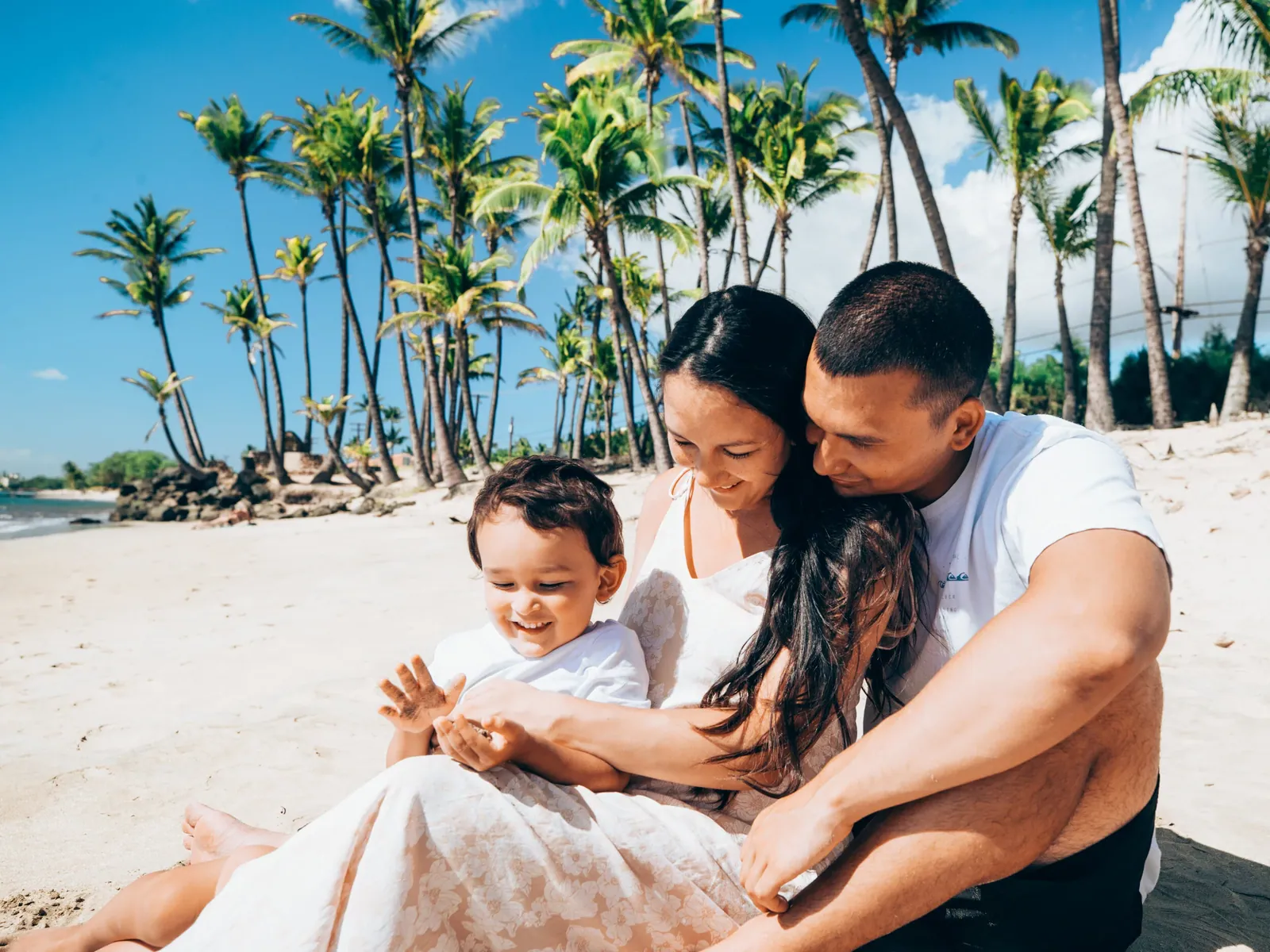 Parents sitting on the sand with their baby during a Maui family session