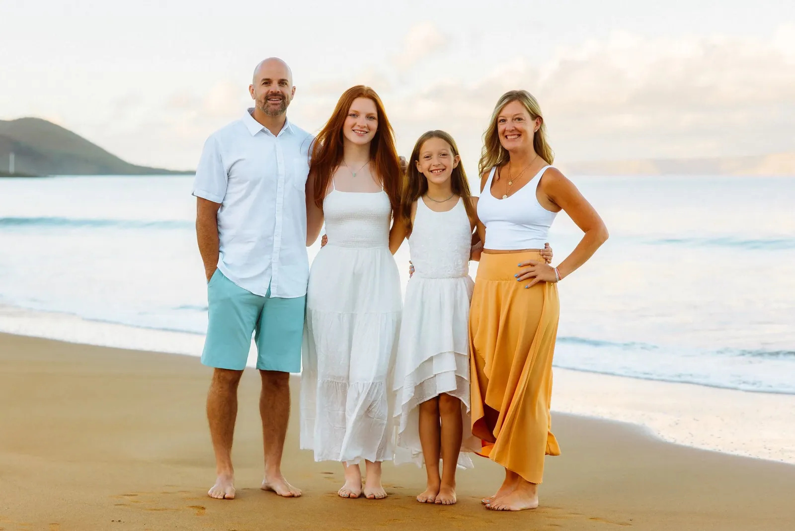 Family walking together silhouetted against a golden Maui sunset