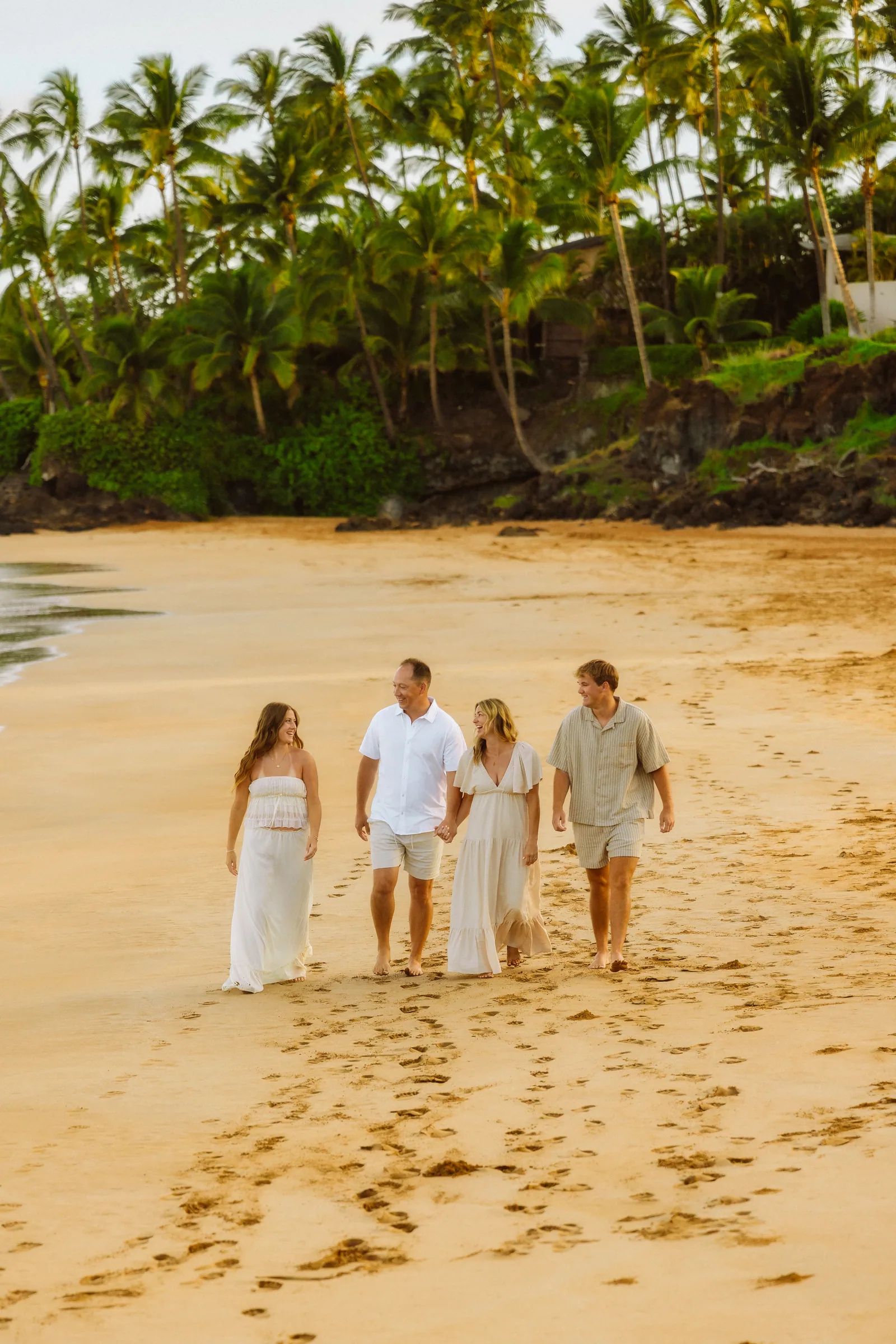 A family walking up the beach together in deep golden light
