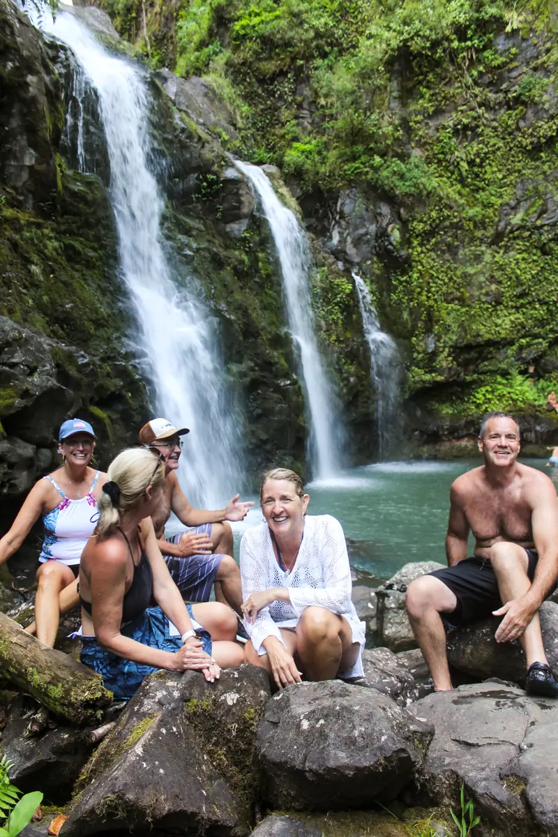 Guests swimming in a waterfall pool off the Hana Highway